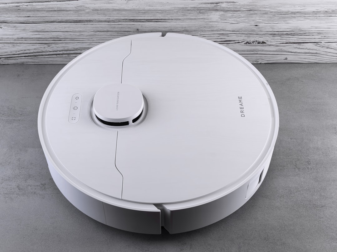 a-white-robot-vacuum-cleaner-on-a-grey-floor-ey7bnptbv4c